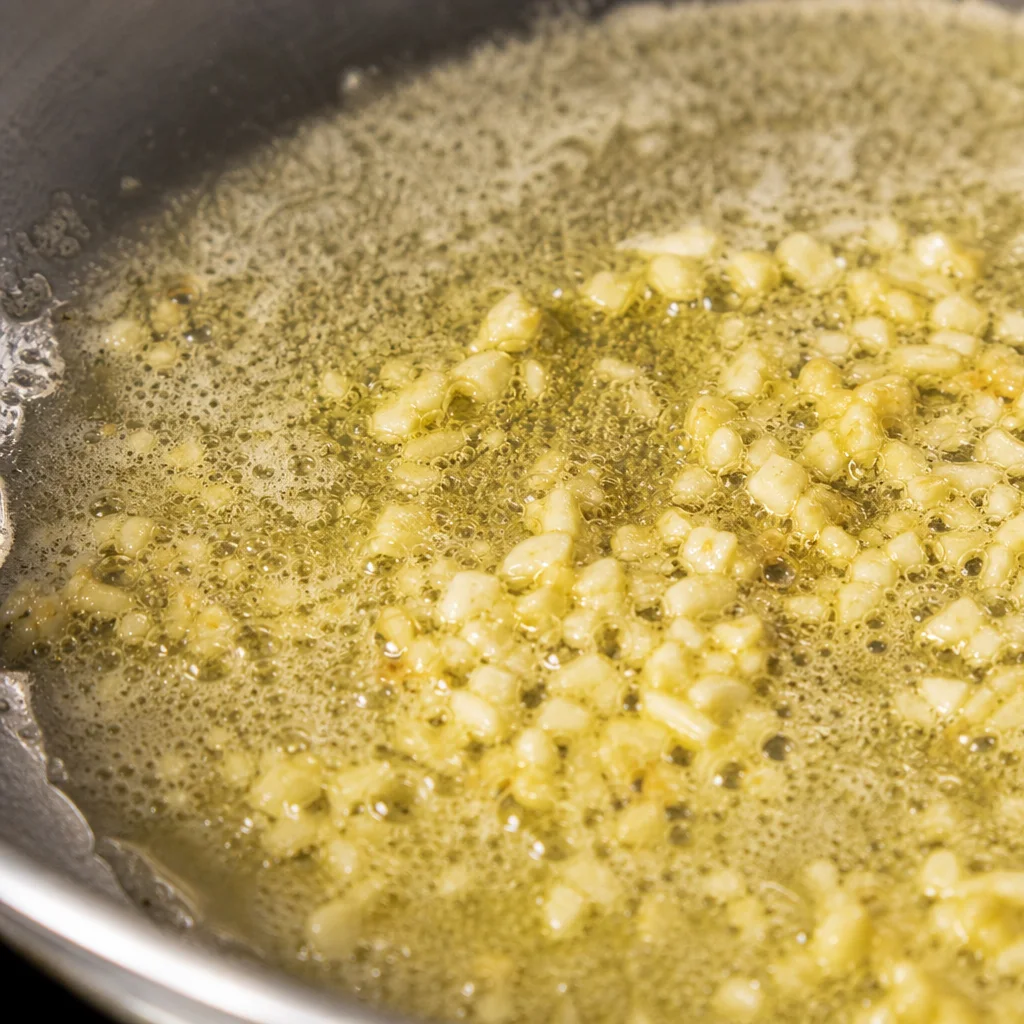 Garlic sizzling in melted butter for shrimp pasta sauce