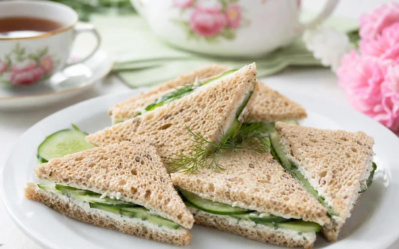 Healthy cucumber sandwiches on whole grain bread cut into triangles with fresh dill