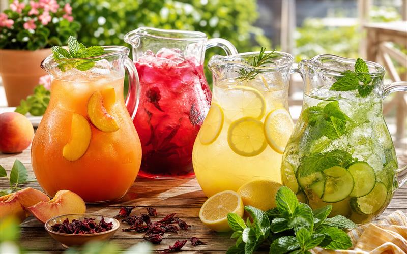Assortment of colorful homemade iced tea recipes in glass pitchers for summer