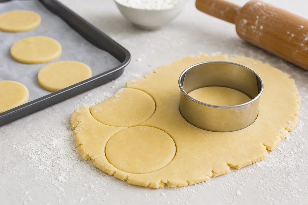 Cutting rolled sugar cookie dough into rounds before baking