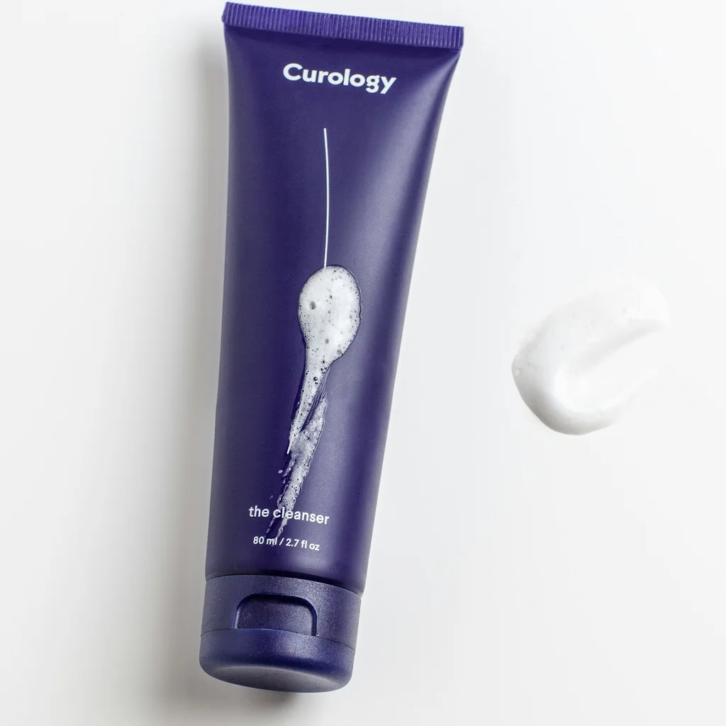 Gentle facial cleanser and cotton pad on a bathroom counter for daily skincare