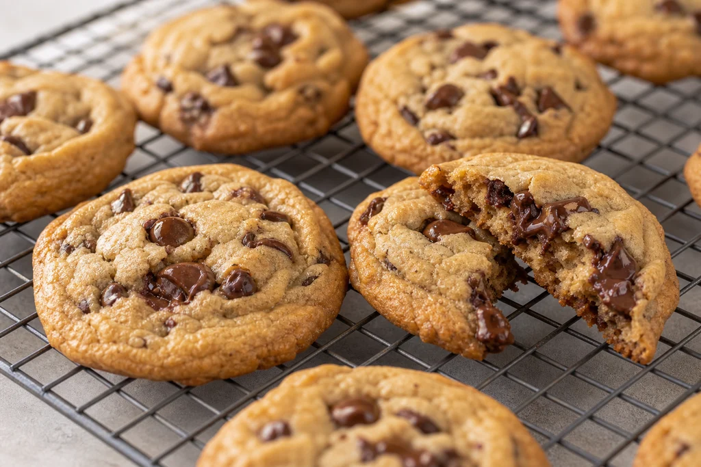 Freshly baked soft chewy chocolate chip cookies cooling on a wire rack