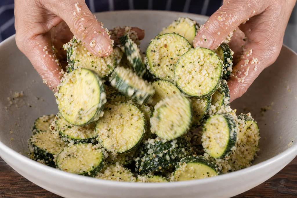 Zucchini rounds tossed with parmesan garlic coating and olive oil