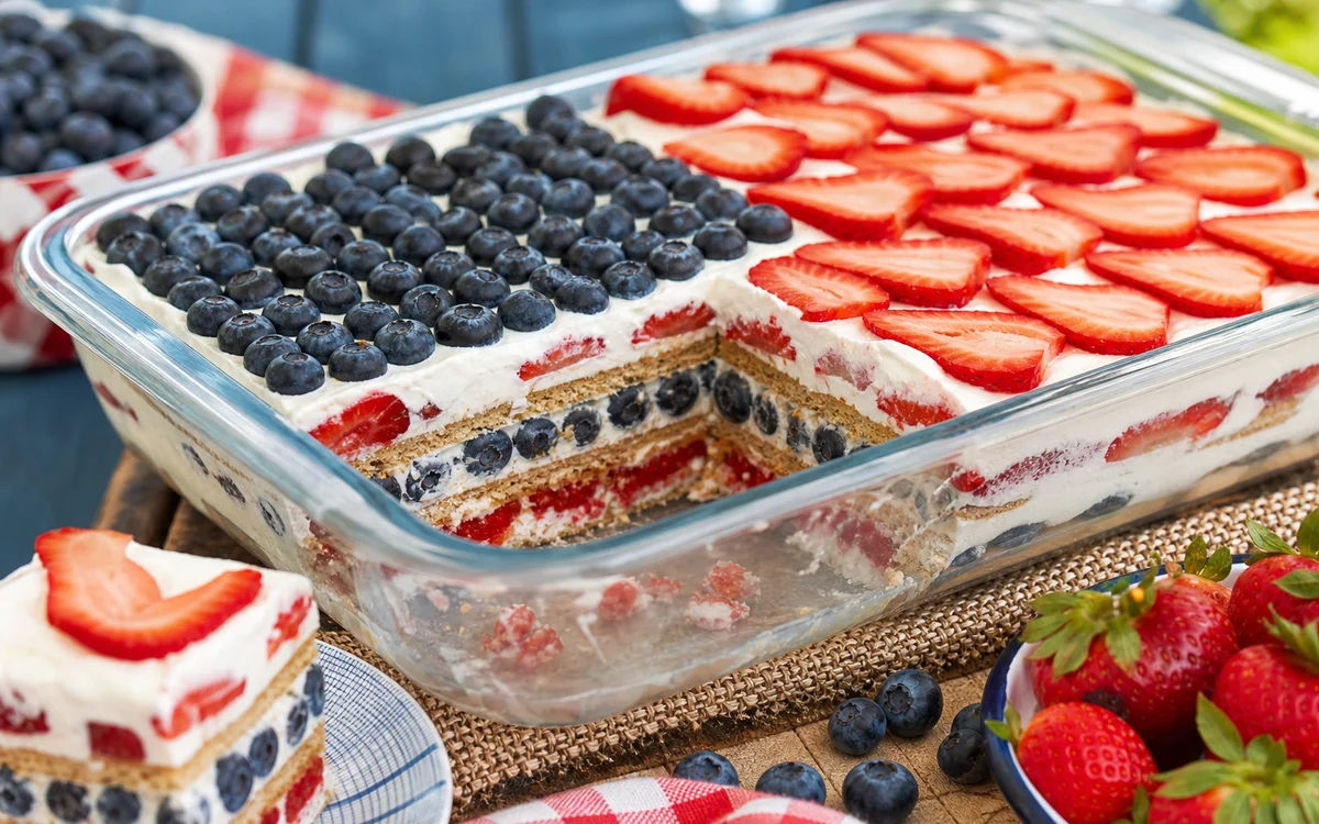 Sliced red white and blue berry icebox cake with patriotic berry layers