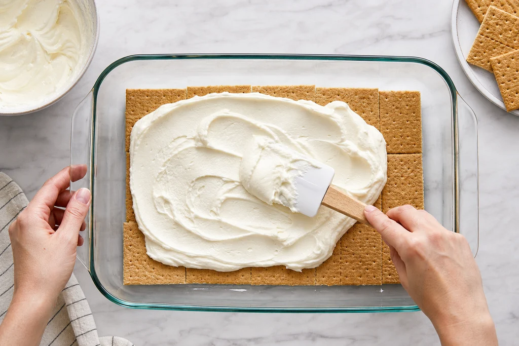 Building graham cracker and cream layers in a 9x13 dish for icebox cake
